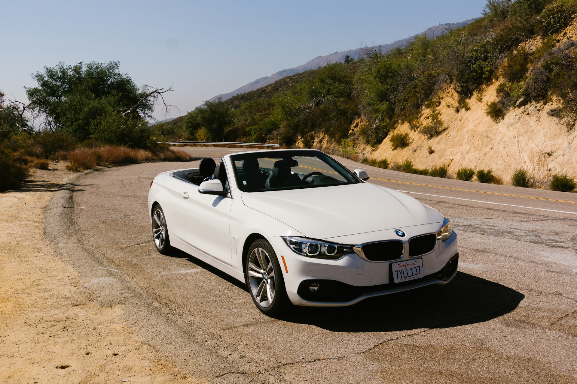 Baltas BMW 4 serijos kabrioletas atviru stogu